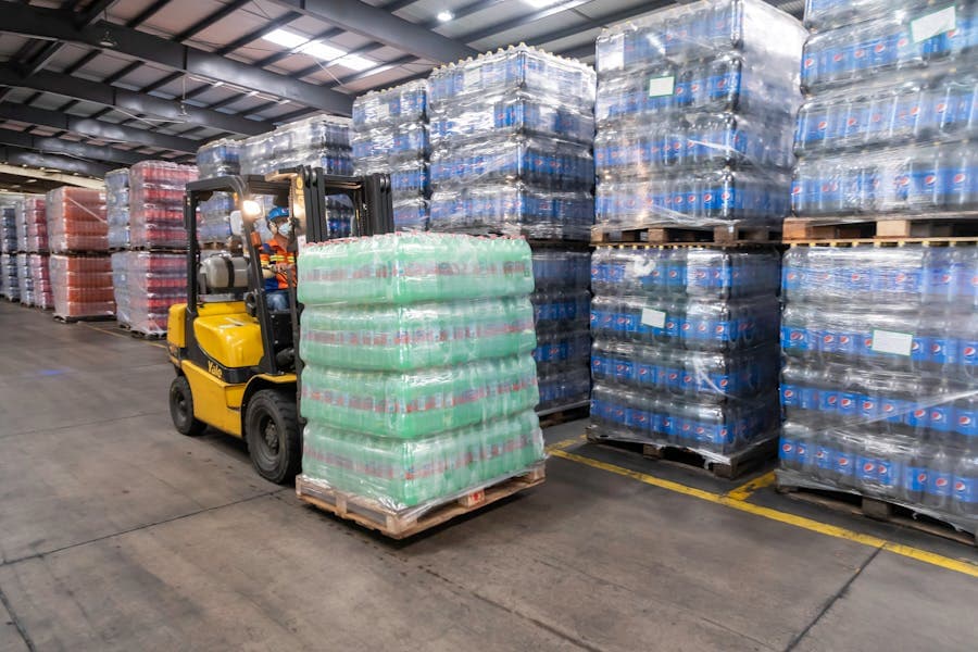 Forklift moving packed pallets in a warehouse